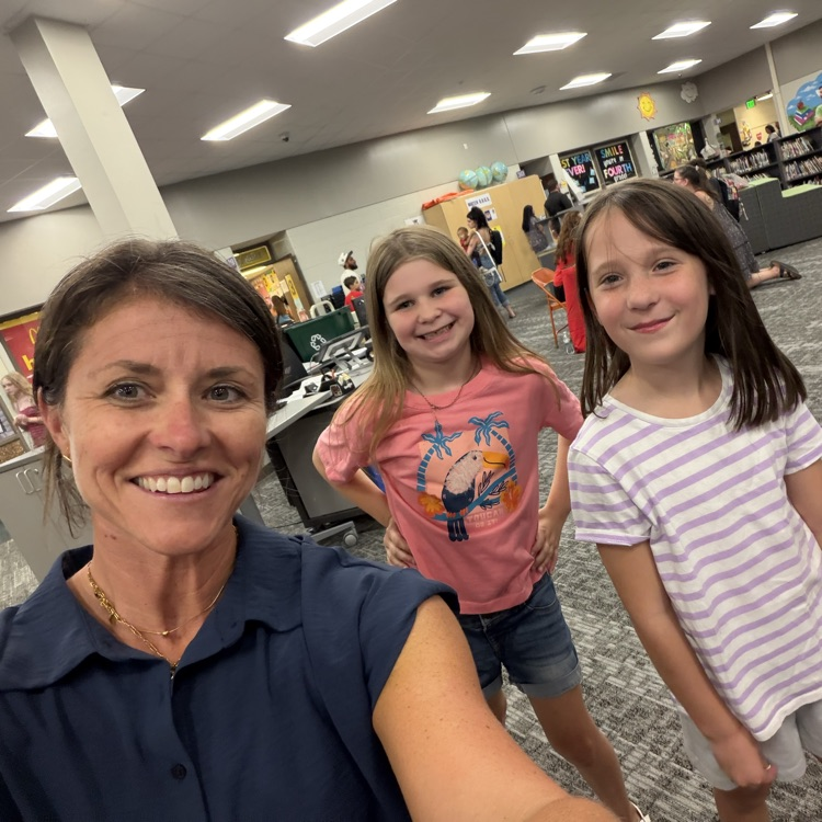 principal standing with two students