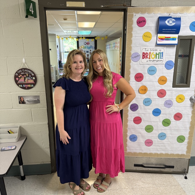 2 Chapman kindergarten teachers posing in front of a door