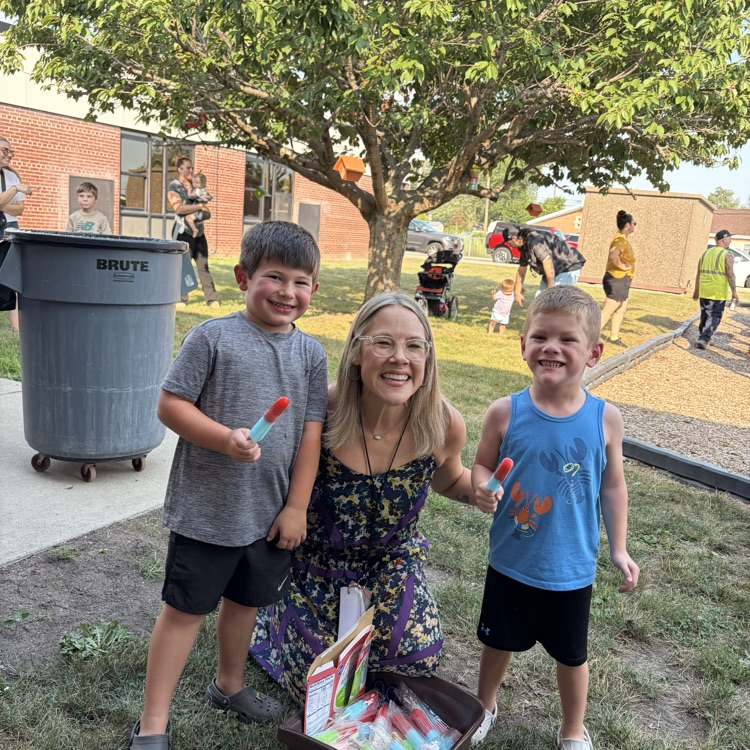 principal posing with two students