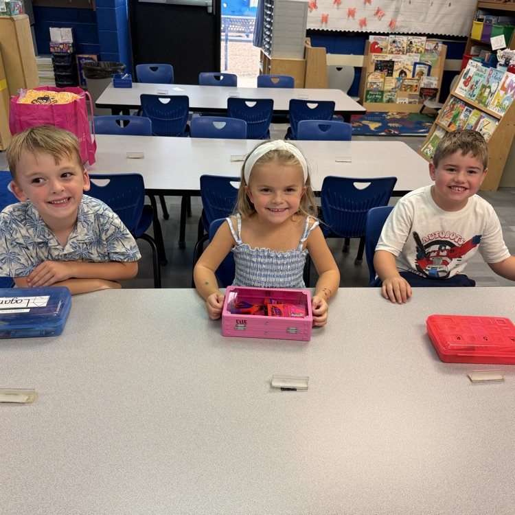 three students sitting at their desk