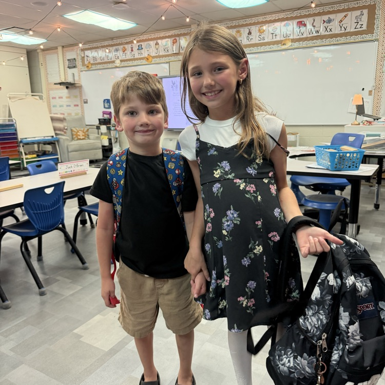 two students posing with their backpack