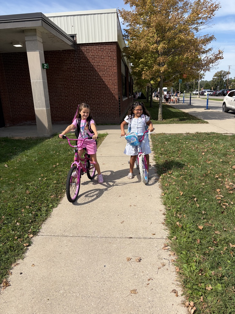 Two girls biking to school