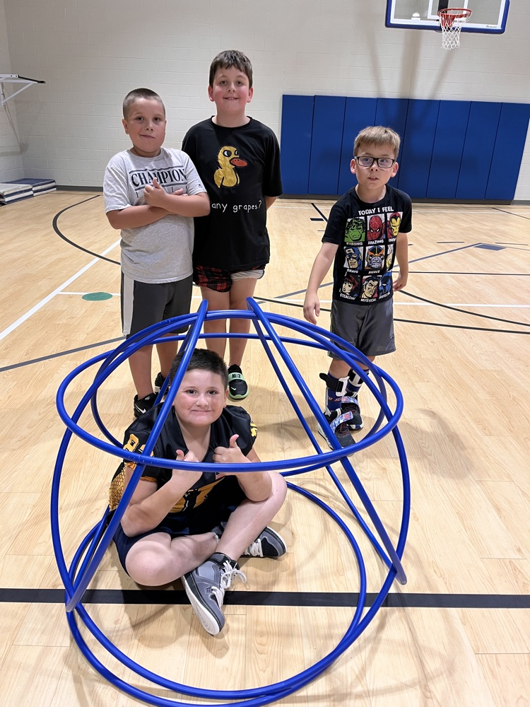 Chapman third- through fifth-grade students pose proudly in front of the hula huts they built during Physical Education.