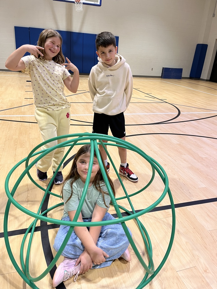Chapman third- through fifth-grade students pose proudly in front of the hula huts they built during Physical Education.