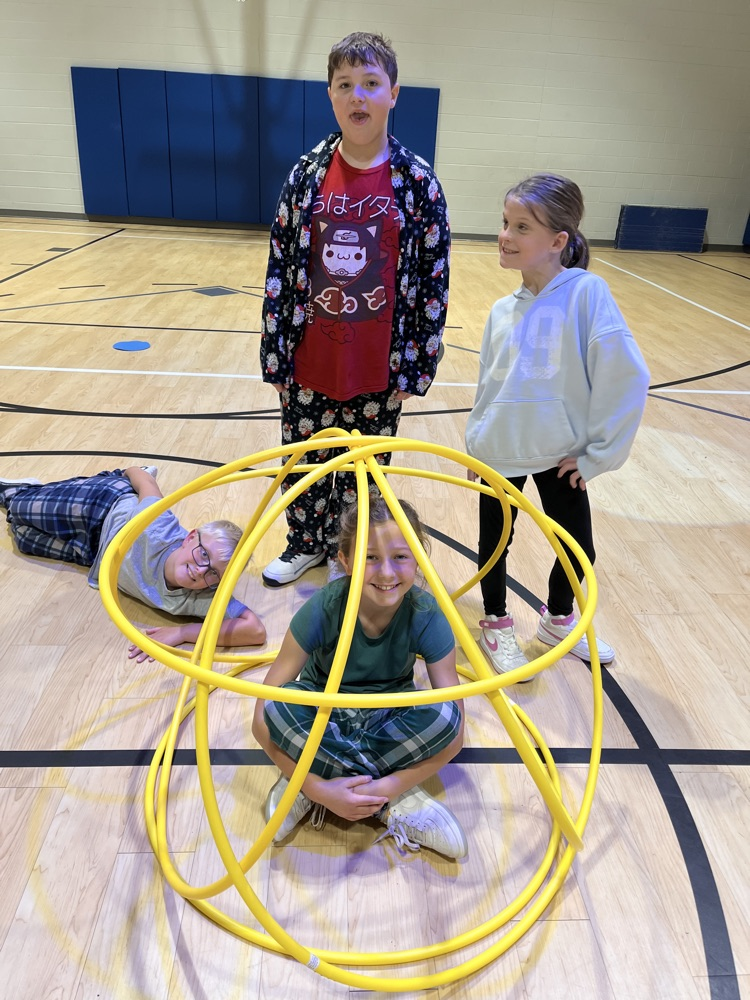 Chapman third- through fifth-grade students pose proudly in front of the hula huts they built during Physical Education.