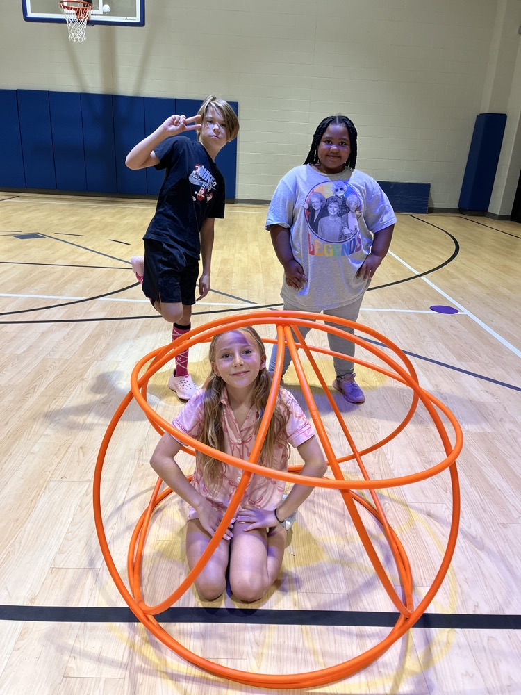 Chapman third- through fifth-grade students pose proudly in front of the hula huts they built during Physical Education.