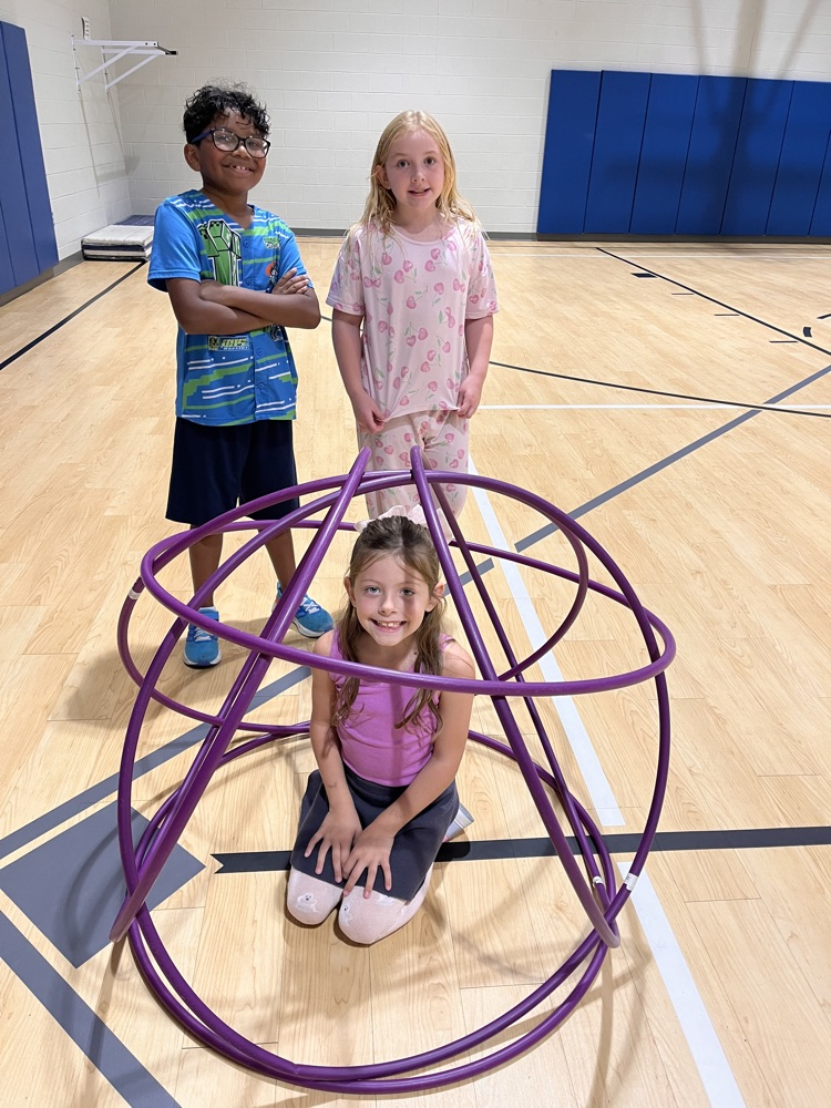 Chapman third- through fifth-grade students pose proudly in front of the hula huts they built during Physical Education.