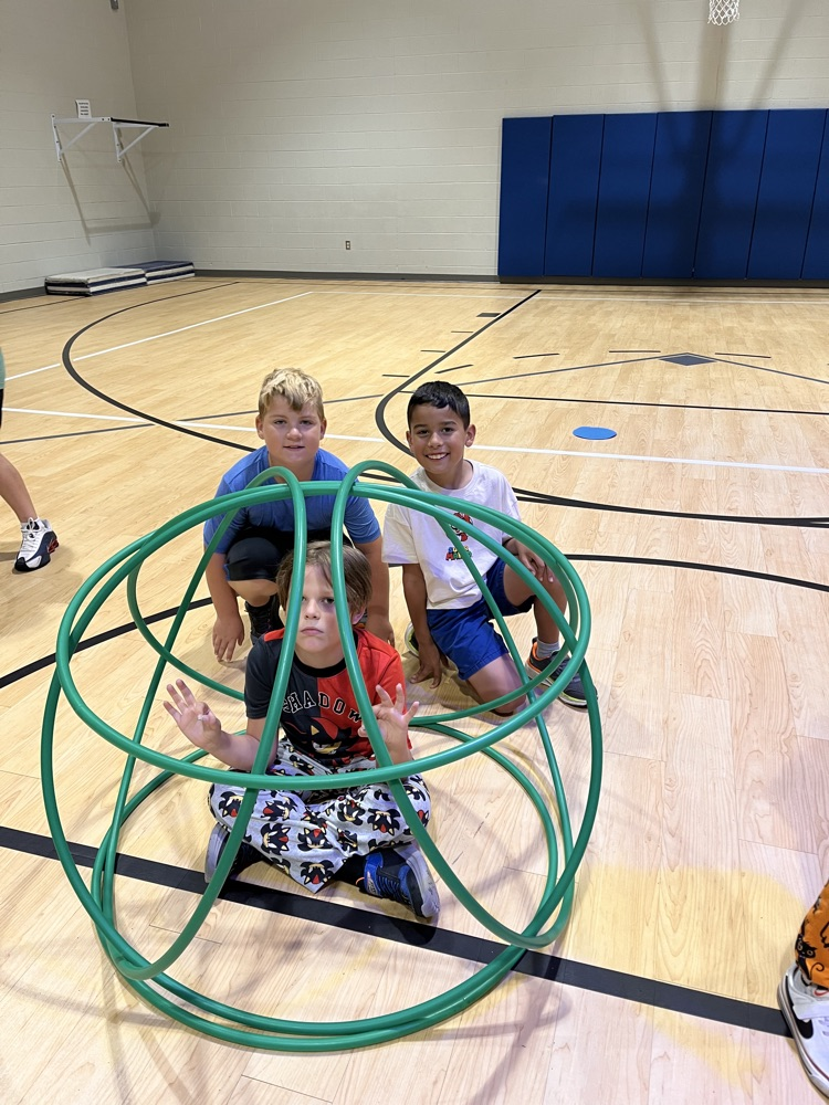 Chapman third- through fifth-grade students pose proudly in front of the hula huts they built during Physical Education.