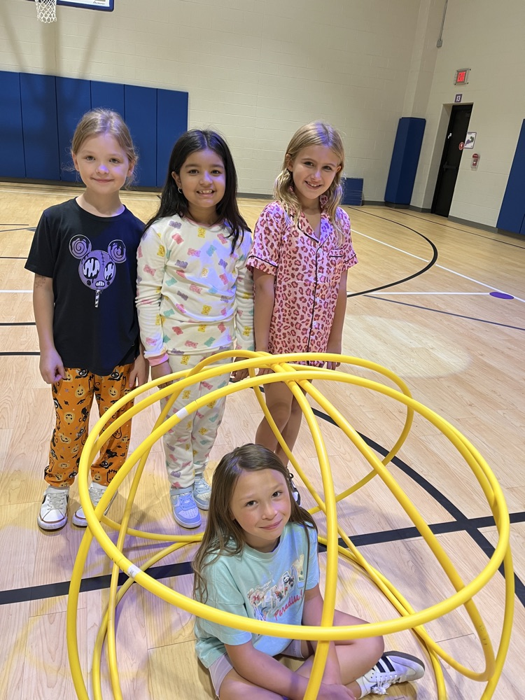 Chapman third- through fifth-grade students pose proudly in front of the hula huts they built during Physical Education.