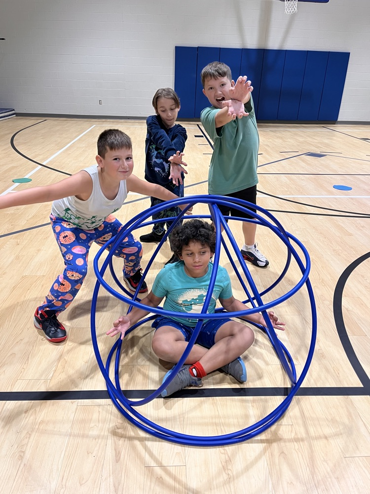 Chapman third- through fifth-grade students pose proudly in front of the hula huts they built during Physical Education.