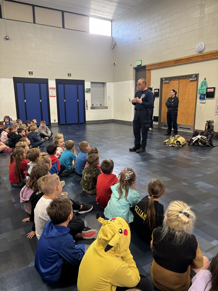 K–2 students sitting together during the fire safety assembly. The fire chief talking to students about fire safety.