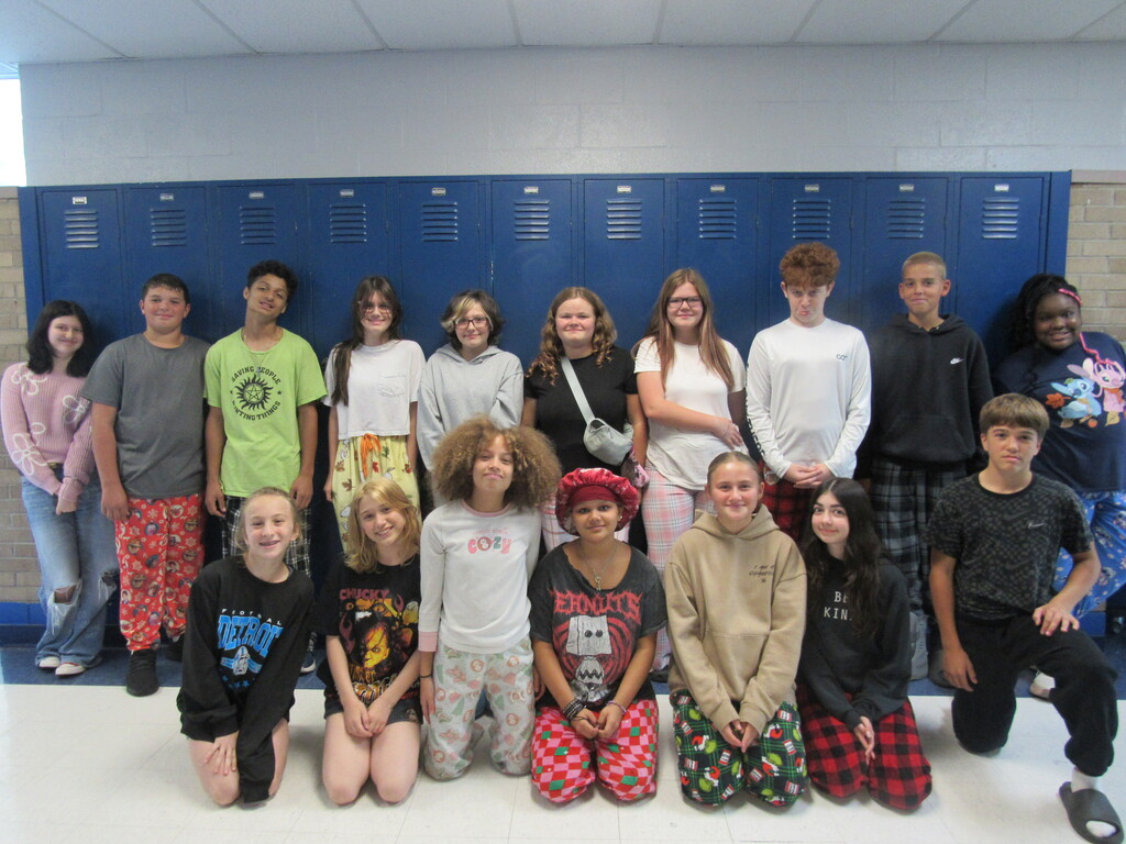 A group of students poses with the lockers in the background wearing their pajamas for PJ Day