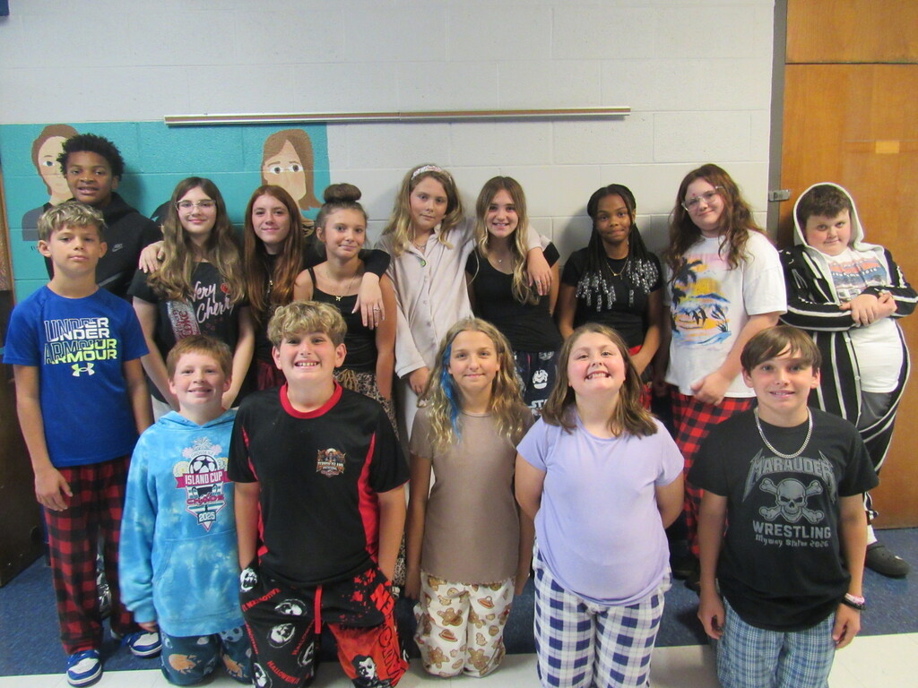 A group of students poses with the lockers in the background wearing their pajamas for PJ Day