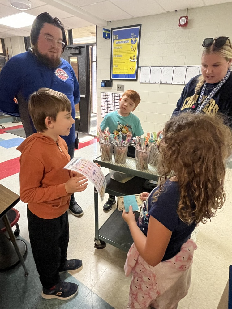 Alt text: Chapman students shop for colorful, scented Smencils from a classroom cart during the Peer to Peer Program’s Smencil Sale.