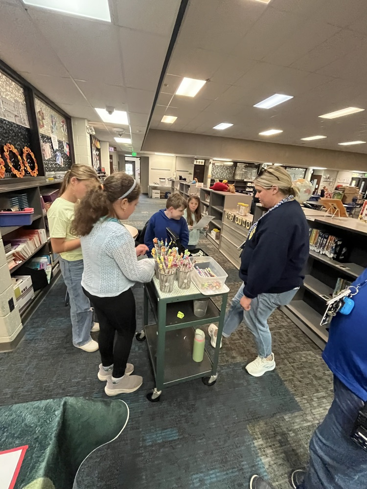 Alt text: Chapman students shop for colorful, scented Smencils from a classroom cart during the Peer to Peer Program’s Smencil Sale.