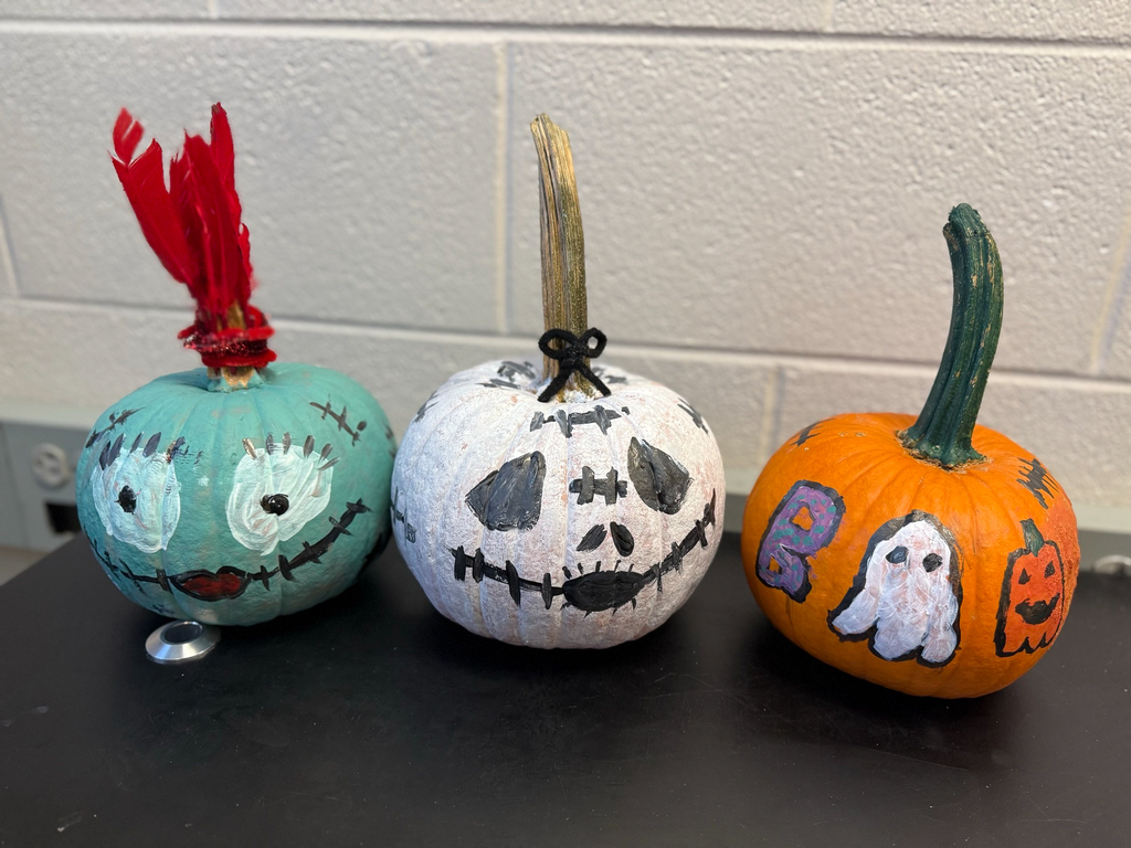 three painted pumpkins. the first one looks like a mummy, the second a skeleton, and the third says "boo" 