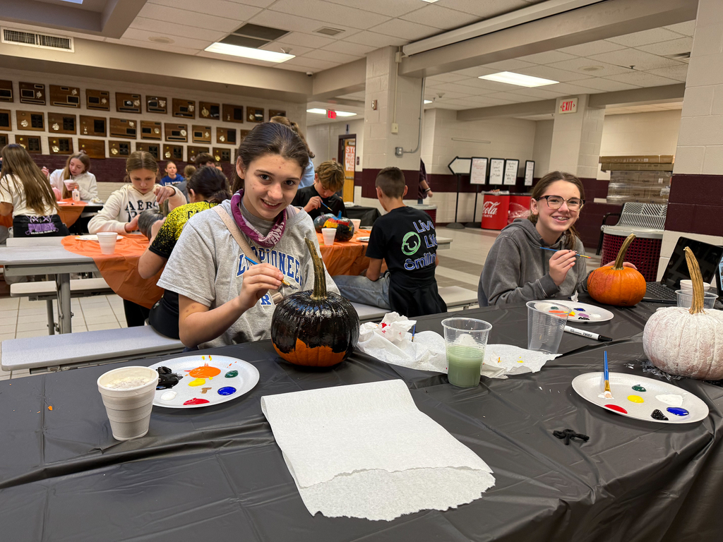 student painting a pumpkin all black