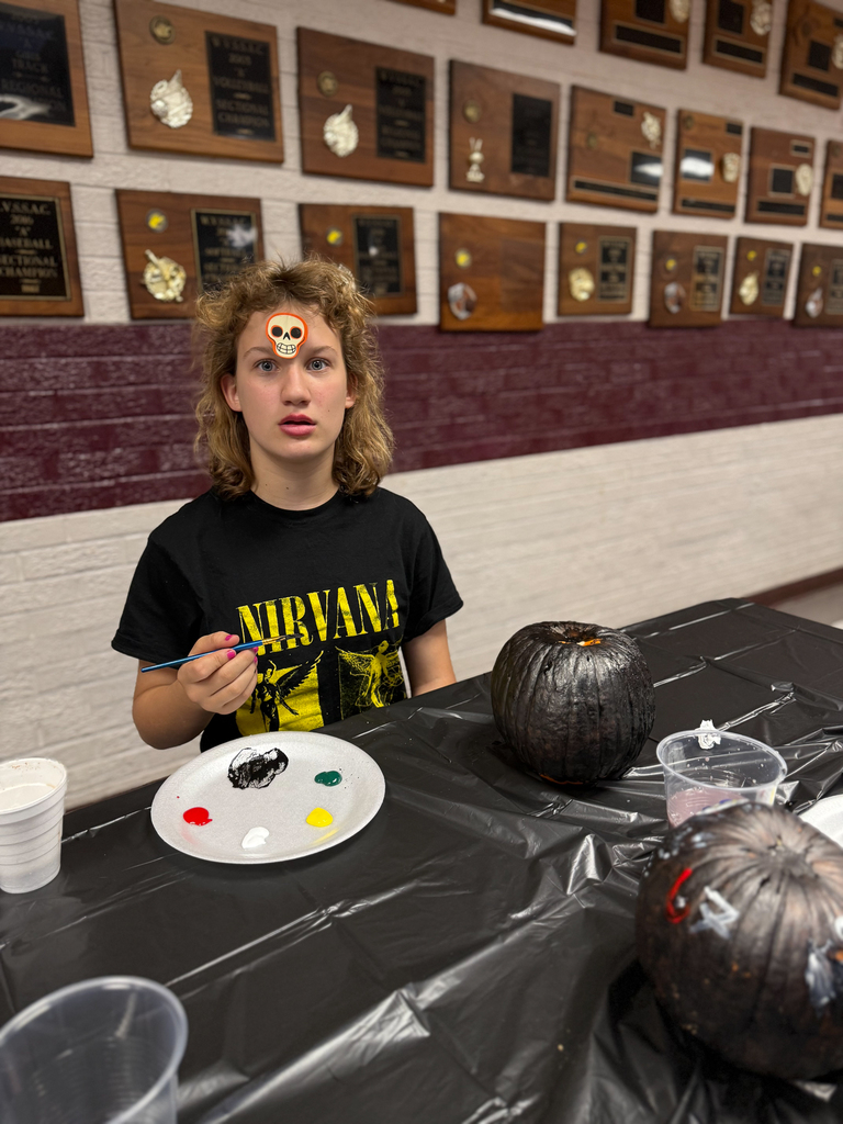 student with an all-black pumpkin and a sticker on their head