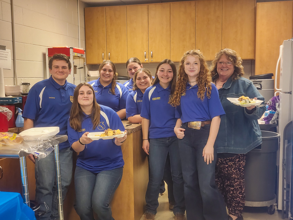 FFA officers in the concession stand with pulled pork. Mrs. Montgomery is also standing with a plate.