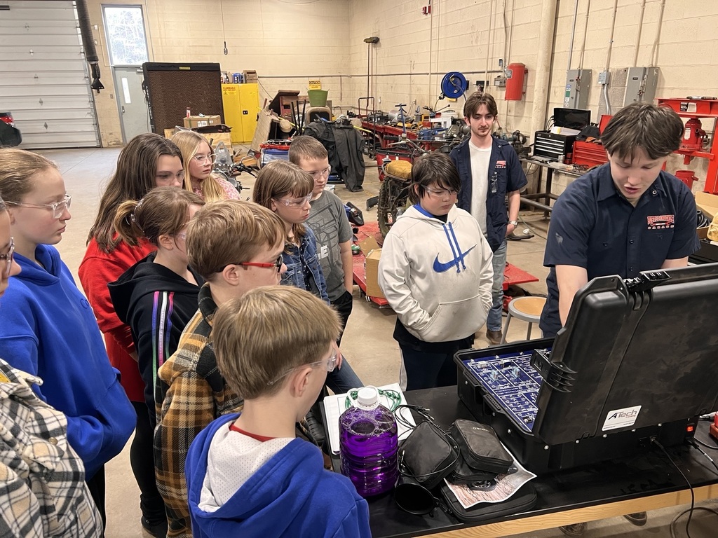 a group of students examining an electrical board
