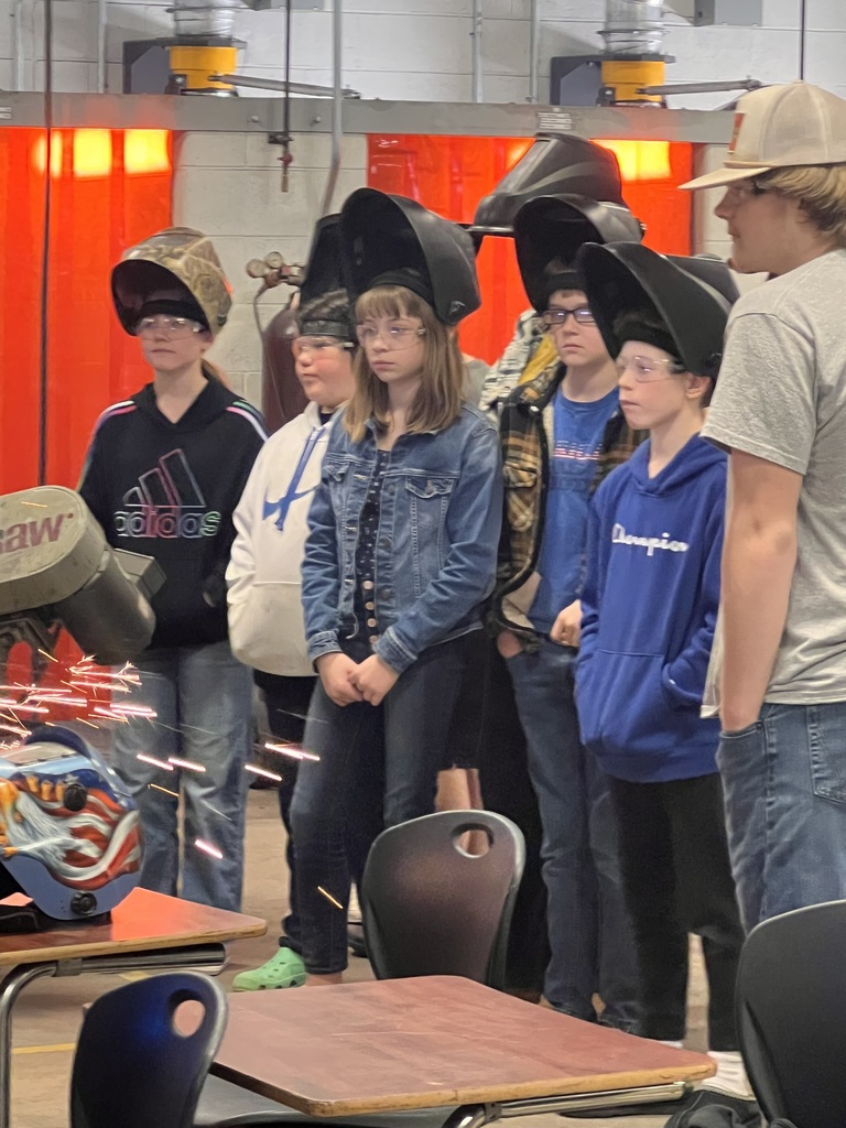 a group of students with welding helmets on