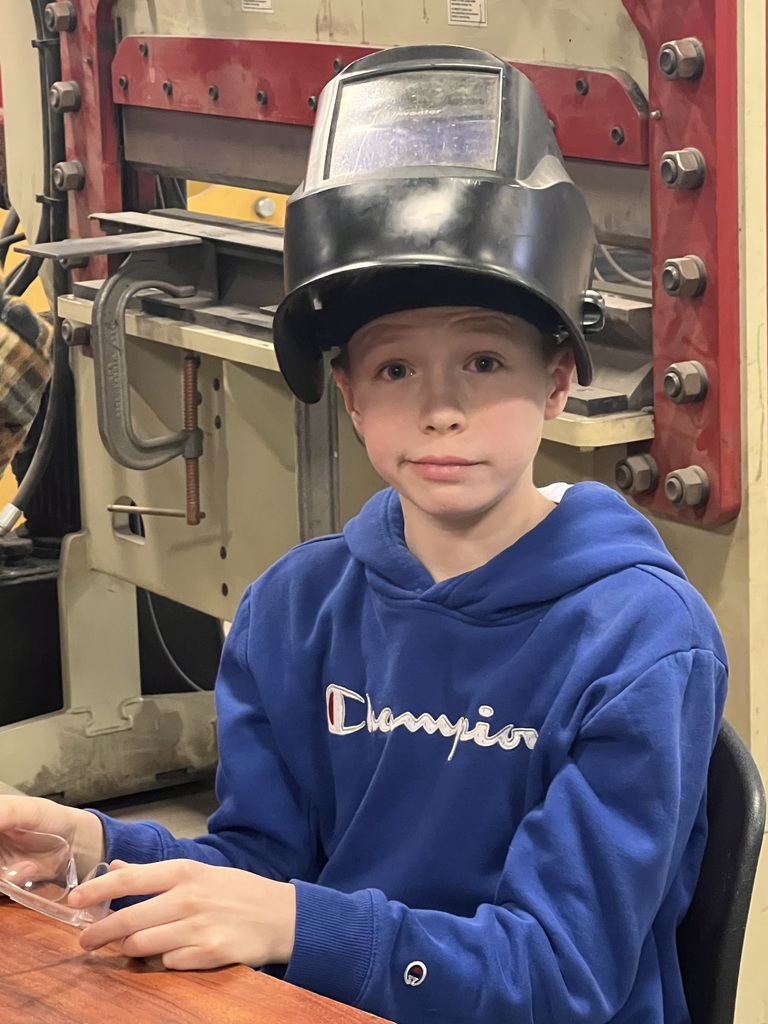 a students with a welding helmet on