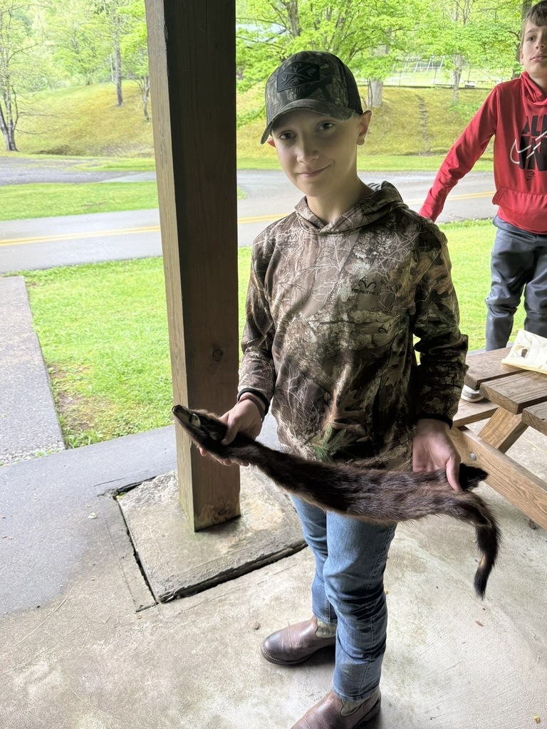 student holding an animal pelt