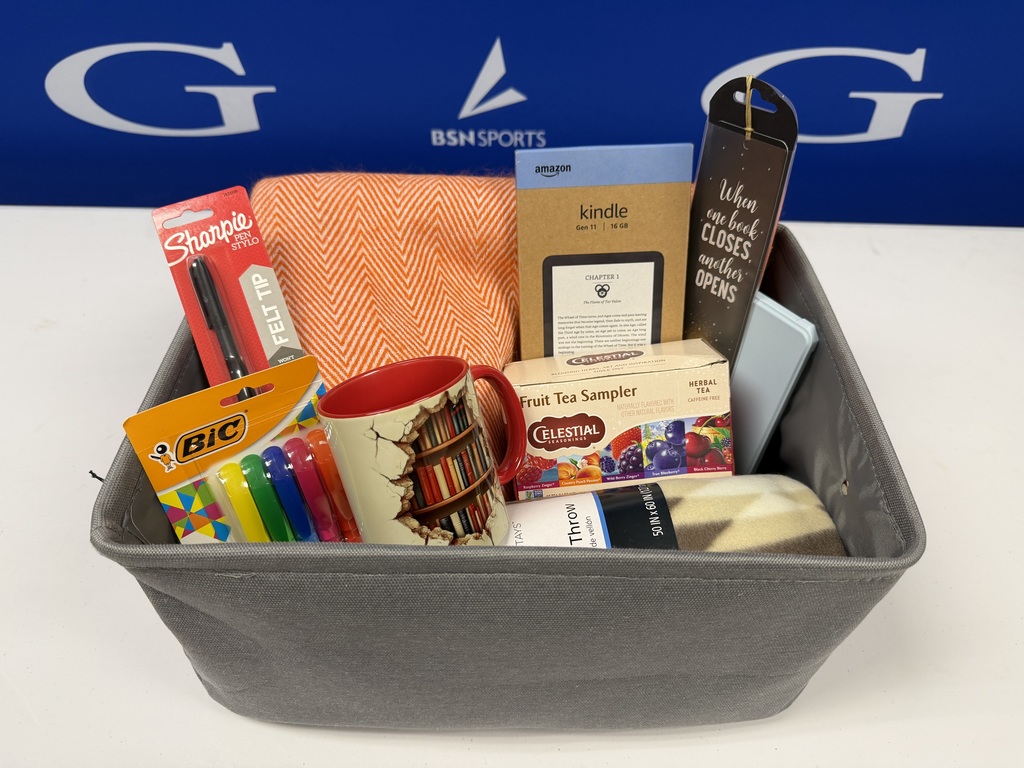 photo of reading supplies such as a kindle, highlighters, a sharpie, a tea sampler set, and a blanket 