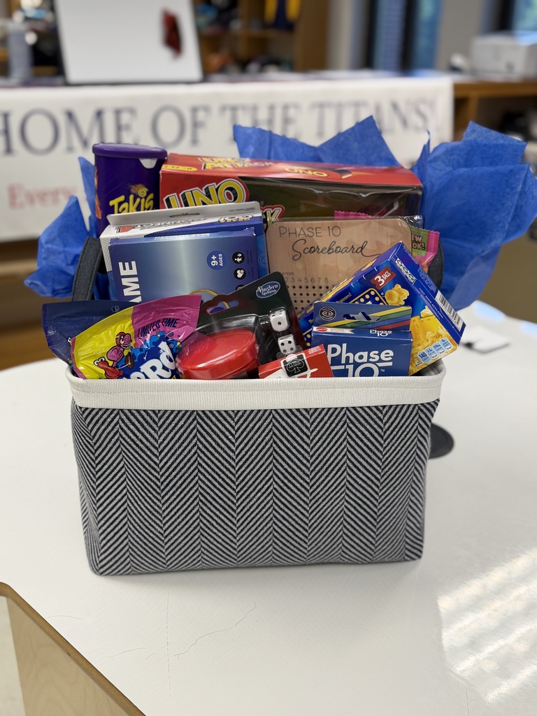 photo of a basket full of table games like uno and phase 10. also in the photo is candy, popcorn, and takis