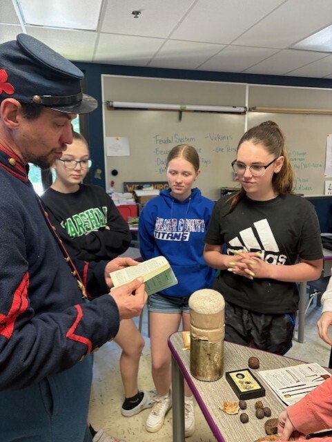 mr. barker showing off civil war artifacts to students