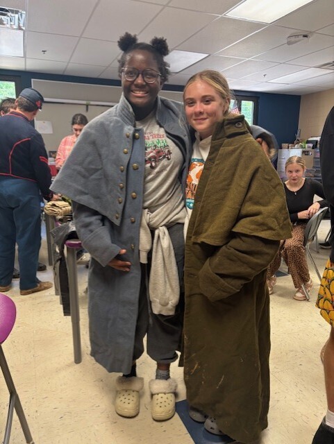 two students posing with civil war attire on