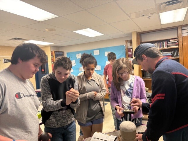 mr. barker with students doing a hands-on activity with civil war artifacts