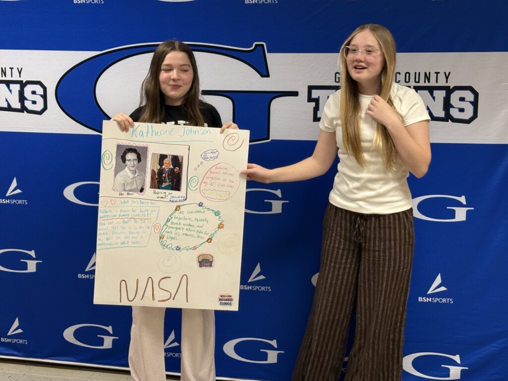 students with a poster about katherine johnson