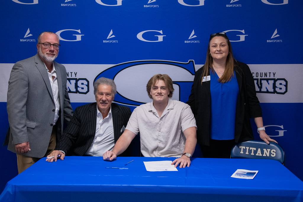 Owen butcher signing with mr. chapman, Dr. Mark Manchin, and other GSU reps