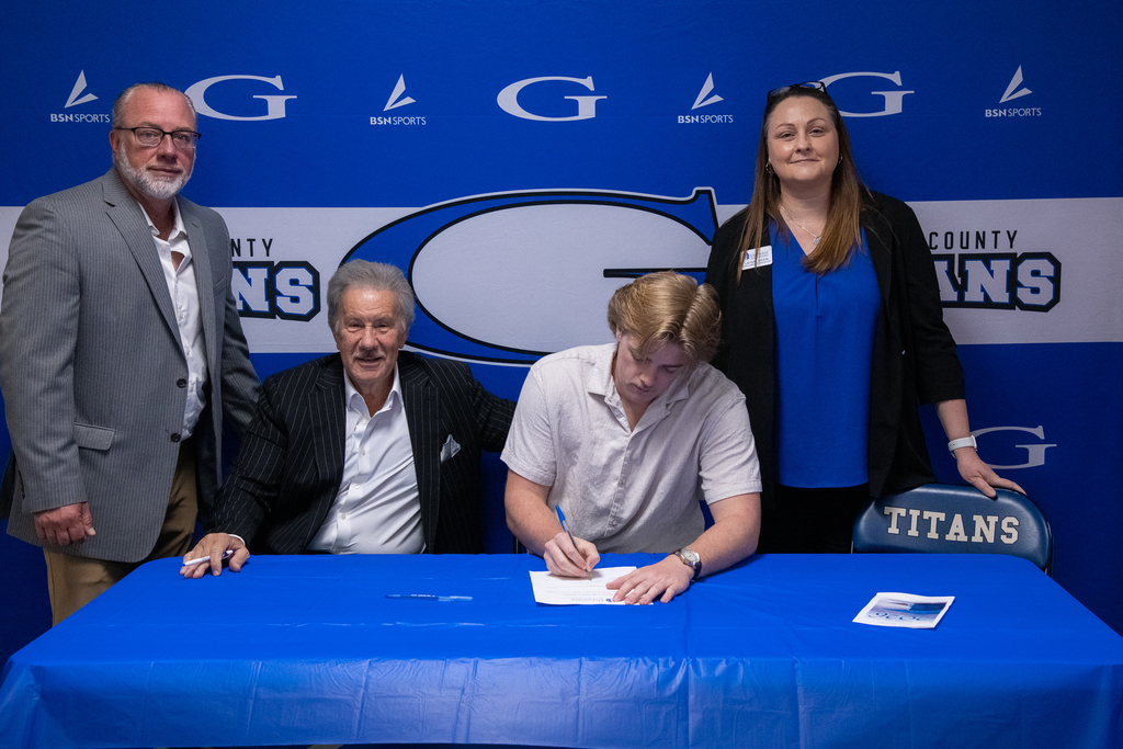 Owen butcher signing with mr. chapman, Dr. Mark Manchin, and other GSU reps