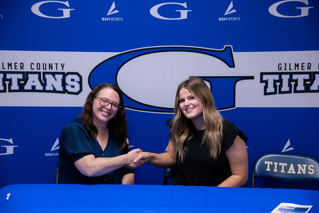 Photo of Elze shaking hands with WVU representatives 