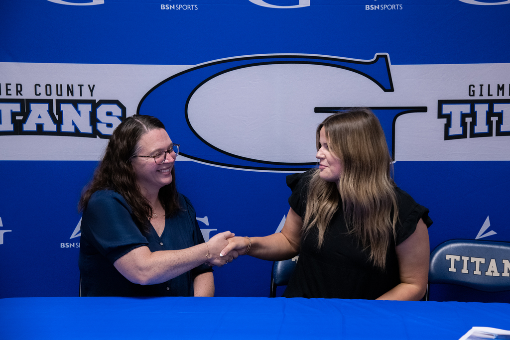 Photo of Elze shaking hands with WVU representatives 