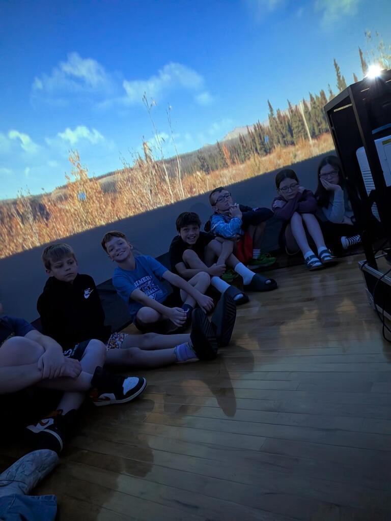 students smiling inside the starlab