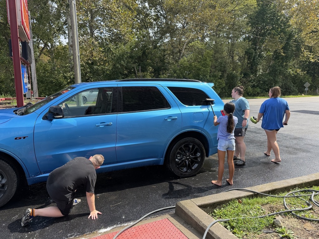 students, ms. allen, and mr. dewall washing cars