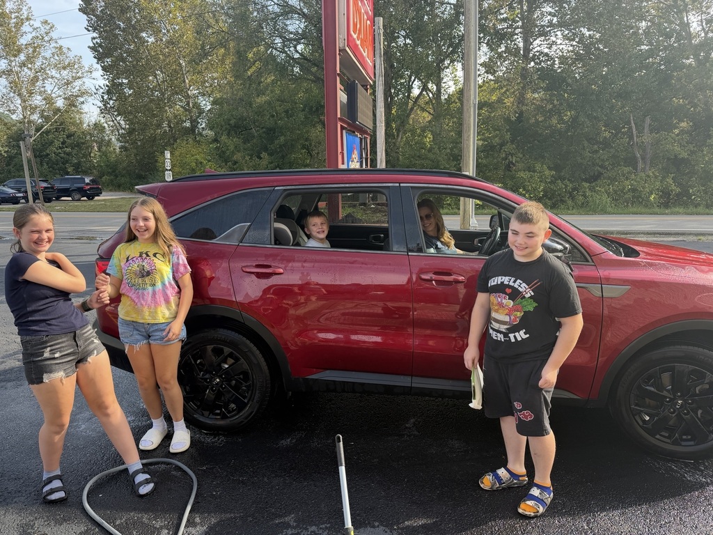 students posing with newly cleaned car
