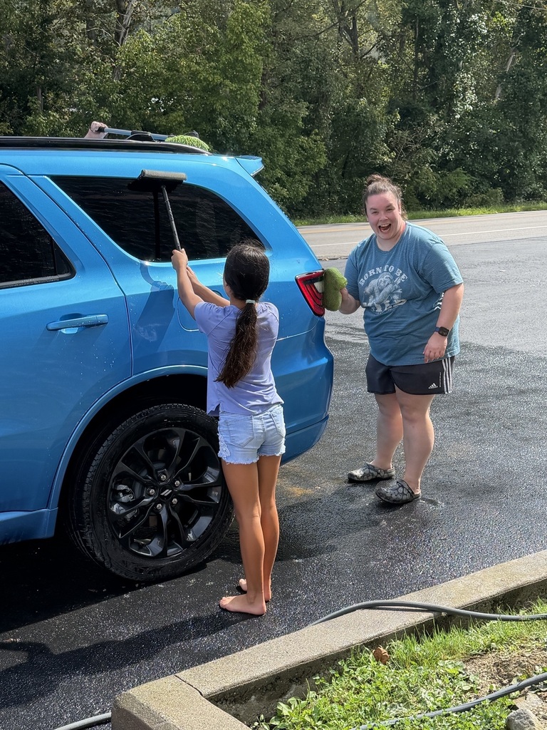 Ms. Allen and a student cleaning her car