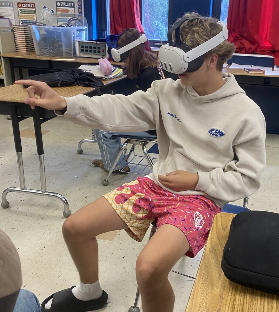 student with VR headset pointing