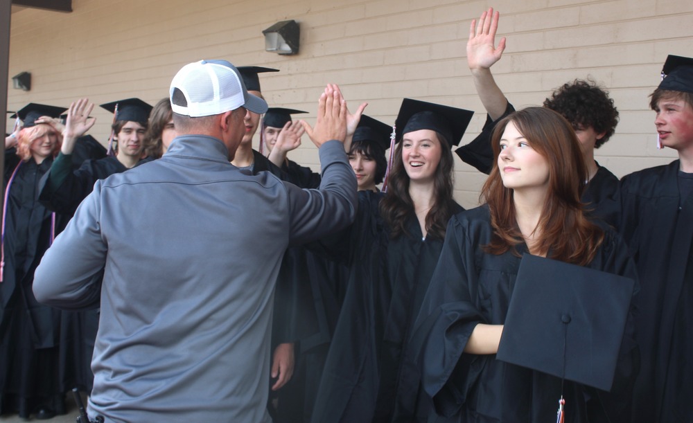 staff giving graduates high fives