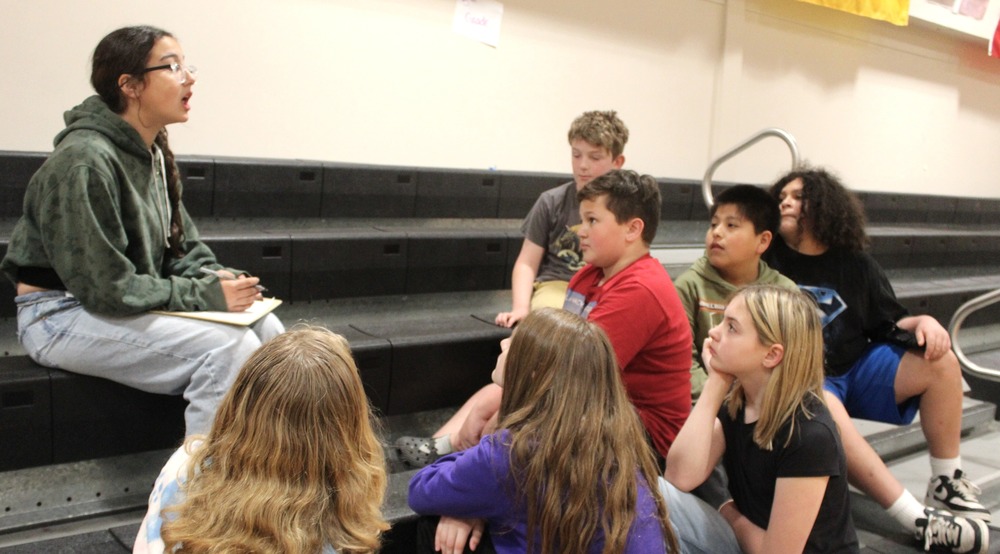 seventh grader talks with fifth graders