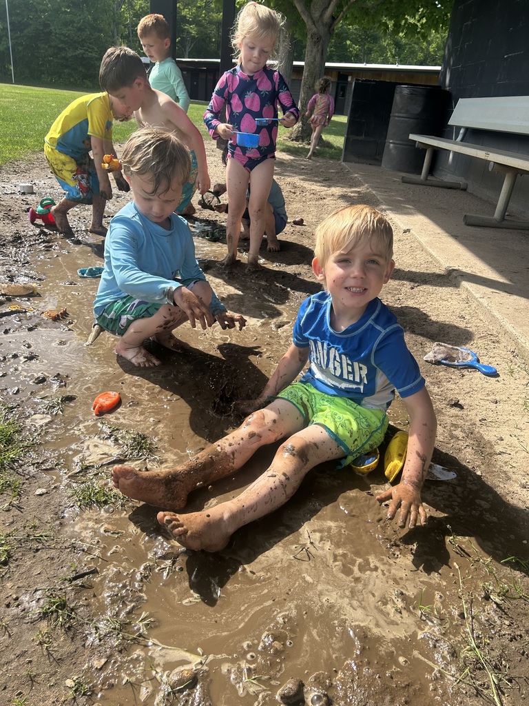 Preschoolers having a blats with water in the dirt