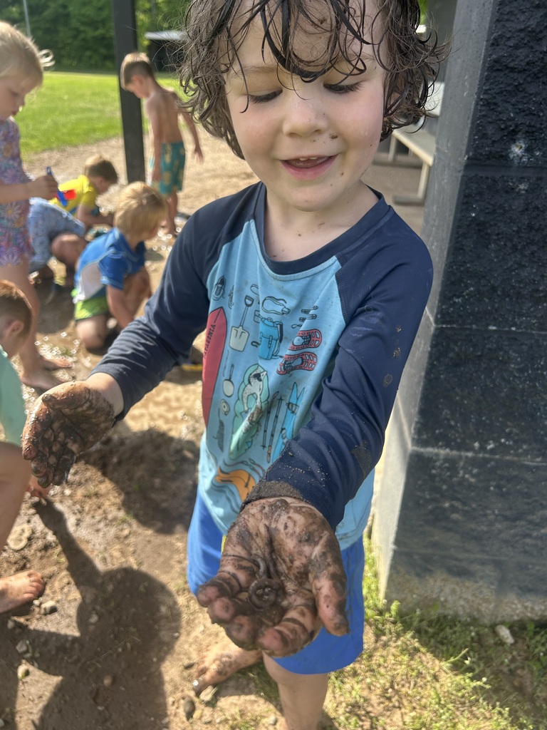 A preschool student is getting muddy