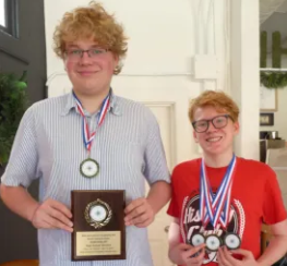 two brothers posing with award