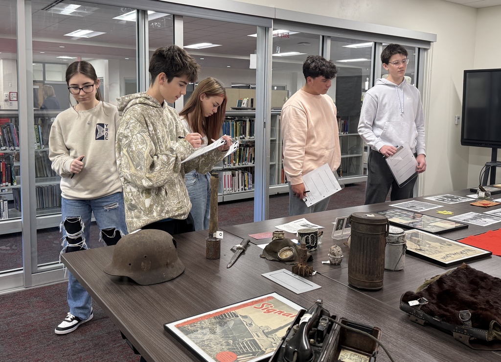 Mrs. Kathy Burns’ and Ms. Susan Sharps’ classes participated in a powerful Gallery Walk after reading Night by Elie Wiesel, exploring WWII and the Holocaust through artifacts, images, videos, music, and artwork.  A special thank-you to Mr. Jim Eccleston for sharing his collection, hosting a station, and taking student questions, and to Mrs. Wrenn Kibler and Mrs. Jessica North for hosting the event in the Library Media Center and helping make this meaningful learning experience possible.