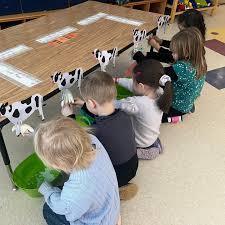 Kindergarten students pretending to milk cows