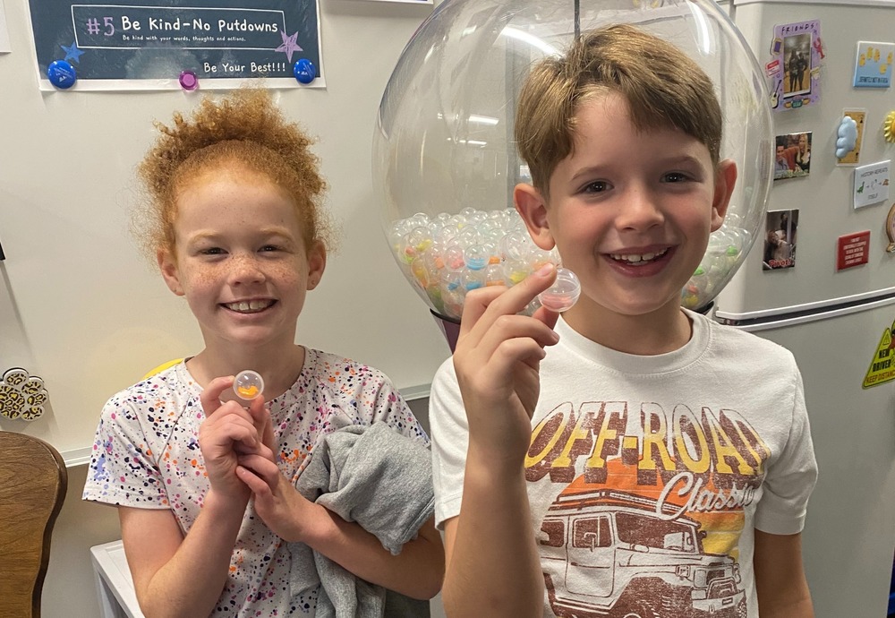 Kids holding up a gumball